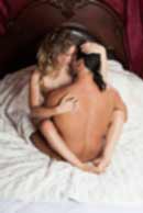 Sexy sensual heterosexual couple, man, young caucasian woman in love on bed kissing, hugging. Beautiful passionate couple is having sex in a bedroom. Portrait of passion, pleasure, sex, relationship. Copulating